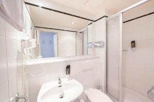 斯图加特Hotel Astoria Stuttgart City的白色的浴室设有水槽和淋浴。