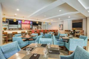 沃尔瑟姆波士顿沃尔瑟姆希尔顿花园旅馆的一间设有蓝色桌椅的餐厅和一间酒吧