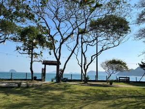 博西坎加Summit Beach Hotel Boiçucanga的公园里种满了树木,长凳,海洋