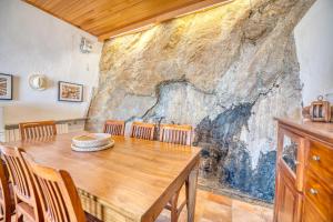 卡莱利亚德帕拉弗鲁赫尔Exclusive Beach House Calella de Palafrugell的一间带木桌和椅子的用餐室