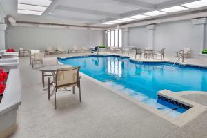 达拉斯达拉斯中央公园区希尔顿合博套房酒店的一个带桌椅的房间,游泳池里是蓝色的