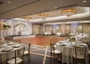 阿林顿阿灵顿希尔顿酒店的宴会厅配有白色的桌椅和舞池