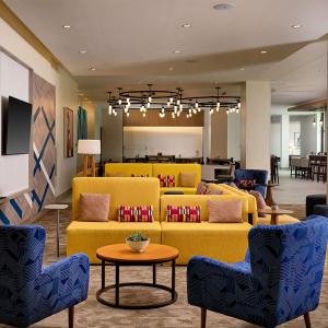 格雷普韦恩Hilton Garden Inn Grapevine At Silverlake Crossing, Tx的大堂设有黄色的沙发和桌椅