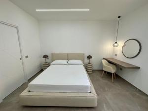 兰佩杜萨Alma Rooms的一间卧室配有一张床、一张书桌和一面镜子
