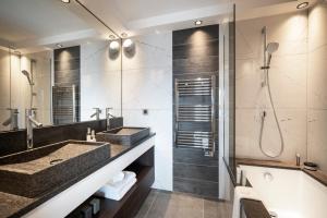 拉赫兹耶尔Hôtel Alpen Lodge的一间带两个盥洗盆和淋浴的浴室
