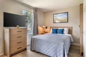 奥兰多InTown Suites Extended Stay Select Orlando FL - UCF的一间卧室配有一张带蓝色枕头的床和电视。