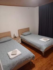 波素斯捷Planinska kuća Rezo Rakitno的客房内的两张床和两条毛巾