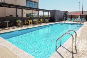 舒格兰Home2 Suites By Hilton Sugar Land Rosenberg的大楼内带桌椅的大型游泳池