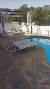 贝纳尔马德纳Tropical Suite的游泳池旁配有桌椅