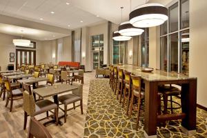 明尼阿波利斯汉普顿宾馆及套房酒店 - 明尼阿波利斯/市中心的一间带桌椅的餐厅和一间酒吧