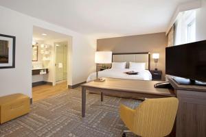 明尼阿波利斯汉普顿宾馆及套房酒店 - 明尼阿波利斯/市中心的一间卧室配有一张床、一张书桌和一台电视