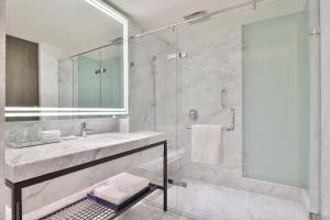 阿姆利则Le Méridien Amritsar的白色的浴室设有水槽和淋浴。