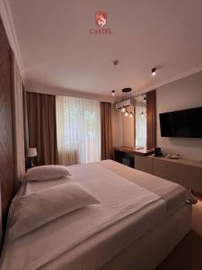 拉姆尼库沃尔恰卡斯特利酒店的一间卧室配有一张大床和电视
