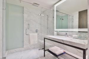 阿姆利则Le Méridien Amritsar的浴室配有盥洗盆和带镜子的淋浴