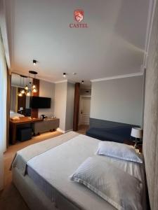拉姆尼库沃尔恰卡斯特利酒店的卧室配有一张白色大床和一张书桌