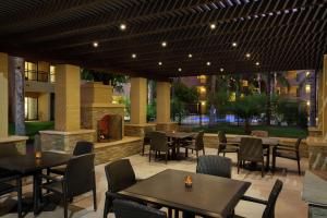 坦培Embassy Suites by Hilton Phoenix Tempe的一间带桌椅的餐厅和庭院