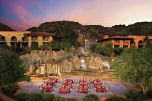 凤凰城Hilton Phoenix Tapatio Cliffs Resort的瀑布前的一组桌椅