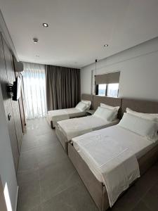 萨兰达Villa Idrizi的酒店客房设有两张床和电视。