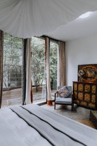 莫希卡里瓦山林小屋的一间卧室配有一张床、一把椅子和窗户。