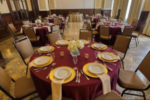 布雷登顿布雷登顿汉普顿套房酒店的宴会厅配有桌椅和紫色桌布