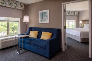 阿林顿Hampton Inn & Suites Arlington Crystal City DCA的一张蓝色的沙发,位于带床的房间