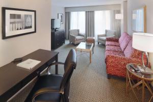 阿林顿Hampton Inn & Suites Arlington Crystal City DCA的一间客厅,客厅配有沙发和一张桌子,位于酒店的房间