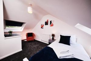 Cassia, 3 Bedrooms, Sleeps 5的卧室配有白色的床和红色椅子