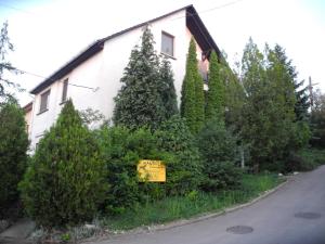 埃格尔Mandula Vendégház的灌木丛前有标志的房子
