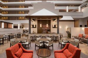 林夕昆高地Embassy Suites by Hilton Baltimore at BWI Airport的一间带桌椅的餐厅和一间酒吧