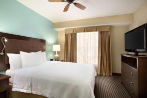 休斯顿休斯敦杨柳溪购物中心希尔顿惠庭套房酒店的一间卧室配有一张床和一台平面电视