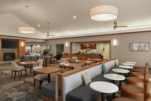 伯利恒阿伦镇伯利恒机场希尔顿惠庭套房酒店的一间带桌椅的餐厅和一间酒吧