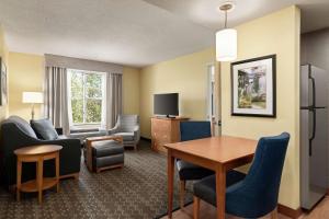 伯利恒阿伦镇伯利恒机场希尔顿惠庭套房酒店的酒店客房设有桌椅和客厅。