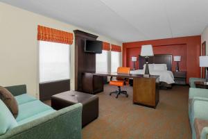 芝加哥芝加哥中途机场希尔顿恒庭酒店的配有一张床和一张书桌的酒店客房