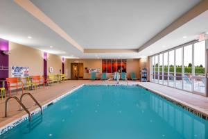 夏洛特夏洛特大学研究园希尔顿欣庭2号套房酒店的一座配有桌椅的酒店游泳池