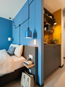 波鸿Nena Apartments Bochum City的一间卧室设有一张床和蓝色的墙壁