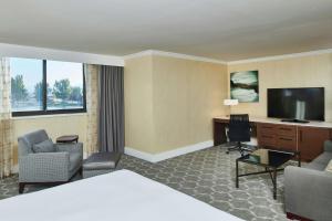 盐湖城盐湖城机场希尔顿逸林酒店的配有一张床和一台平面电视的酒店客房