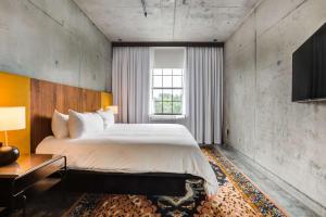 沃里克NYLO Providence Warwick Hotel, Tapestry Collection by Hilton的一间卧室设有一张大床和一个窗户。