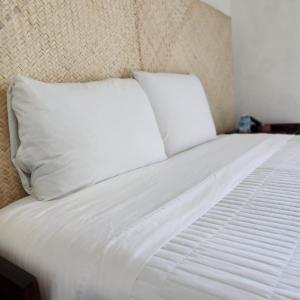 帕伦克Casa Koru的一张白色的床,上面有两个枕头