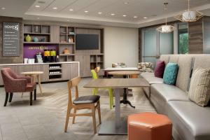迈阿密Home2 Suites By Hilton Miami Doral West Airport, Fl的客厅配有沙发和桌椅