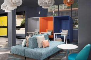 圣安东尼奥Tru By Hilton San Antonio Downtown Riverwalk的一张蓝色的沙发,位于带桌椅的房间