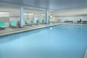 圣安东尼奥Tru By Hilton San Antonio Lackland Sea World的一个带蓝色椅子的大型游泳池