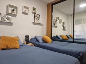 波多黎多德萨贡托Acogedor piso cerca de la playa的配有两张蓝色床单和黄色枕头的客房内的床铺