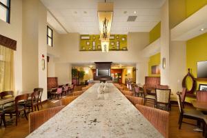 圣安东尼奥圣安东尼奥机场汉普顿酒店及套房的大型大堂设有长桌和椅子