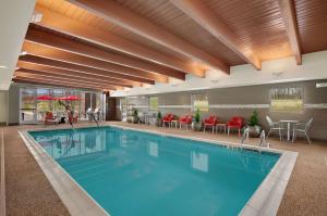 怀特马什巴尔的摩/白色沼泽希尔顿欣庭套房酒店的一座配有红色椅子和桌子的酒店游泳池