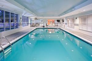 伊萨卡汉普顿宜特艾卡旅馆的大楼内一个蓝色的大型游泳池
