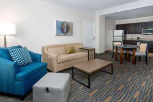 布法罗水牛城市中心汉普顿套房酒店的客厅配有沙发和桌子