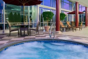 布法罗水牛城市中心汉普顿套房酒店的一个带桌椅的庭院内的游泳池