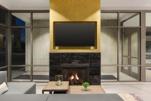 纳什维尔Hilton Garden Inn Nashville West End Avenue的客厅设有壁炉和墙上的电视