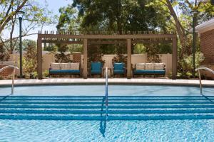 夏洛特夏洛特南园希尔顿花园酒店的一个带椅子的游泳池和一个凉亭