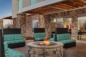 科罗拉多斯普林斯Home2 Suites By Hilton Colorado Springs South, Co的庭院设有两把椅子和一个火坑